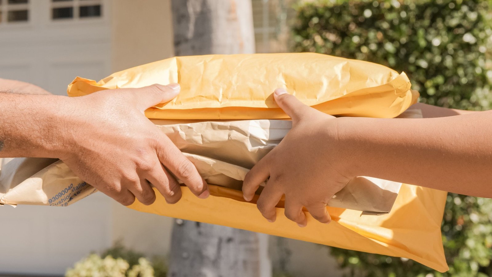 Close-up of two people handing over several parcels outdoors